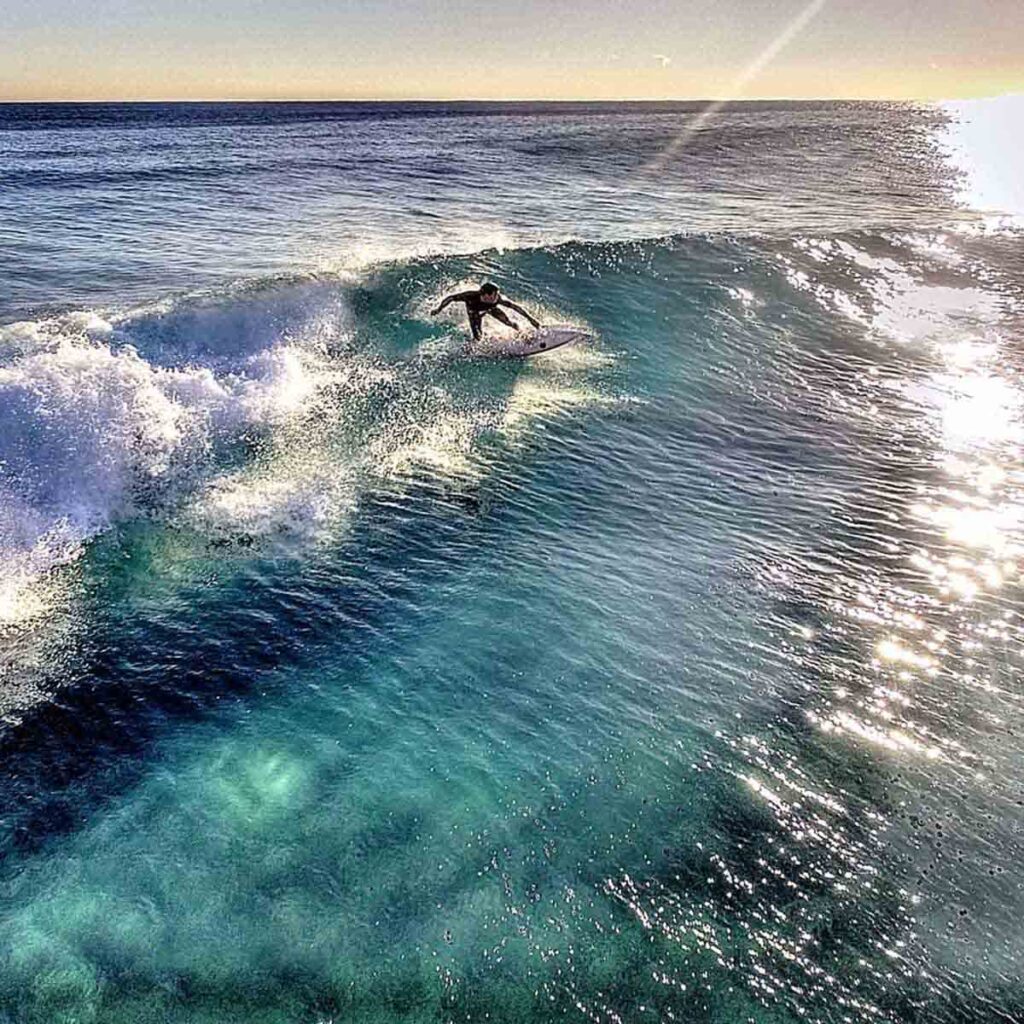 a person surfs in the ocean near Meadows Counseling Center in Palm Beach, Florida