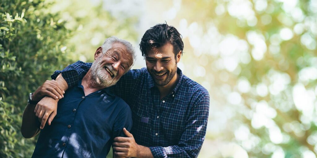 two men side embrace while smiling as they rebuild their personal relationships