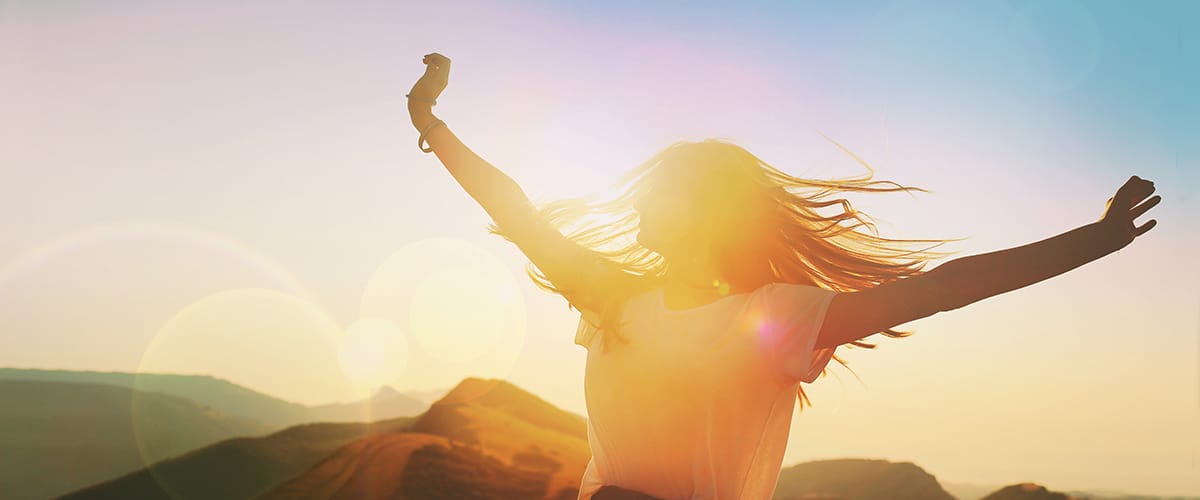 a person stretches their arms at sunrise in the mountains after leaving reviews