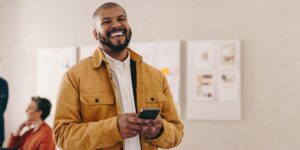 a person laughs while holding their phone as they leave a testimonial