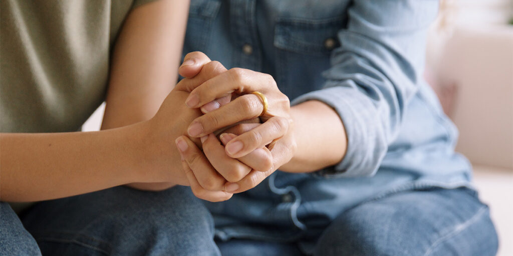 a couple holds hands in support of one another's mental health
